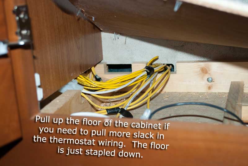Prying up the cabinet floor to pull some wiring slack